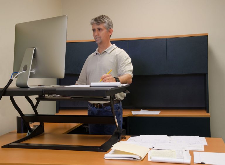 Ergonomic Assessments - man standing at desk using computer